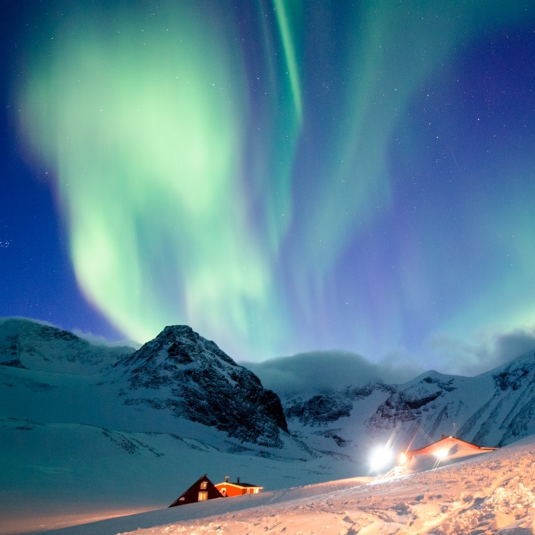 Northern lights above snowy mountains
